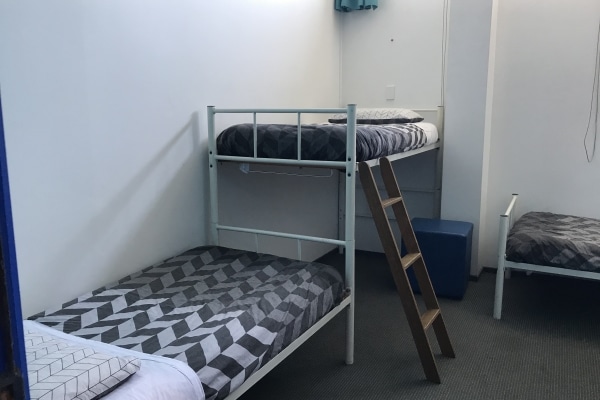 4 Single Beds in a Room. One bed is raised