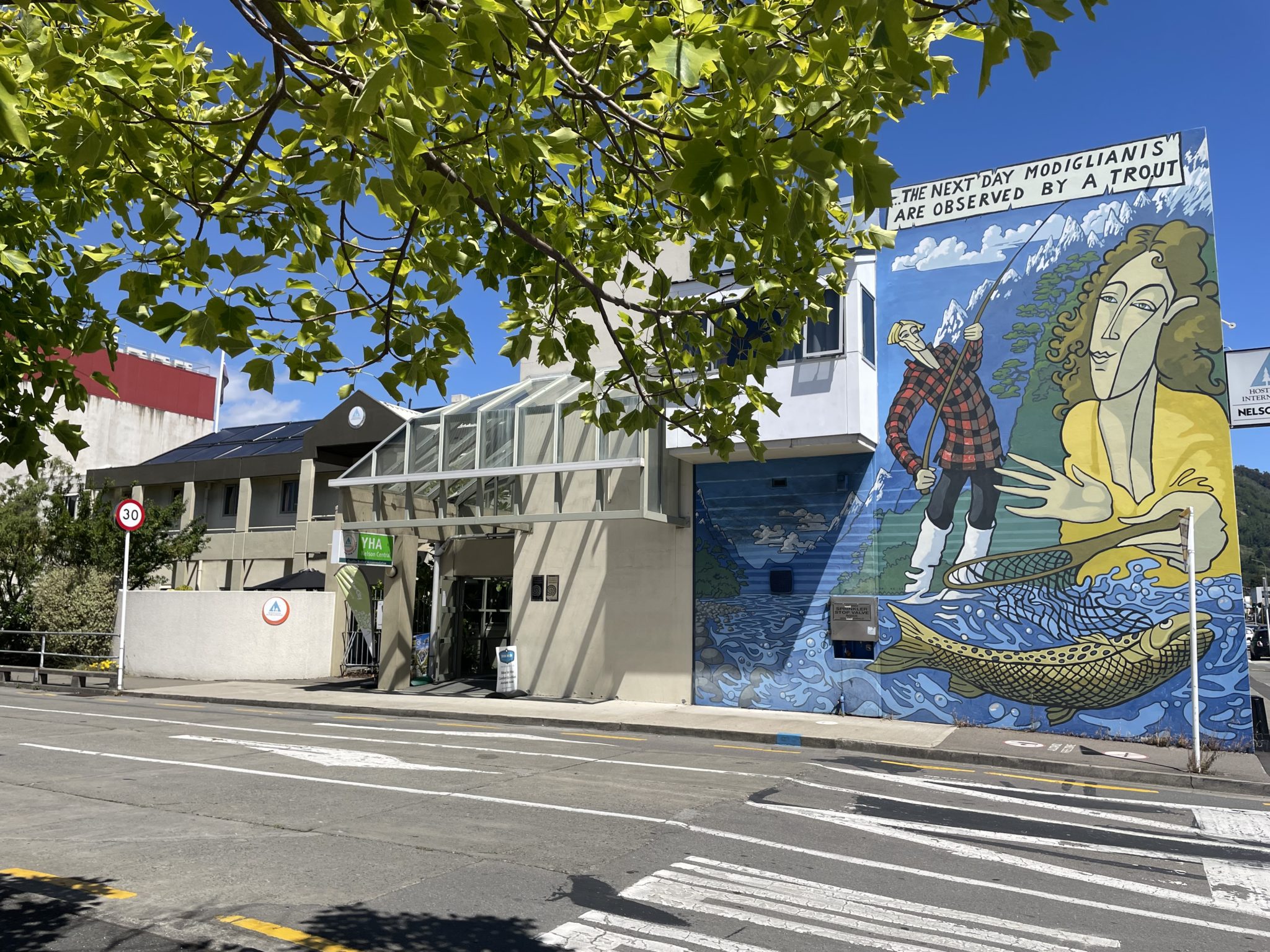 Exterior view of Accents YHA Hostel Nelson showcasing the vibrant mural and main entrance on Montgomery Square